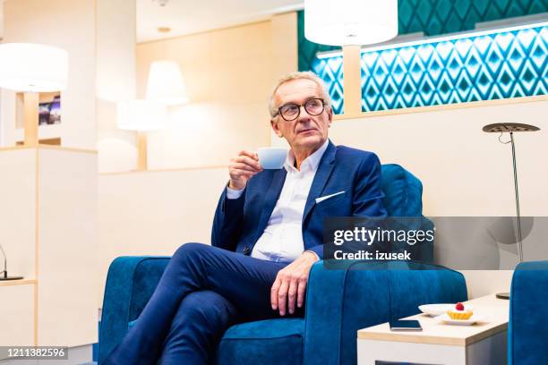 senior businessman sitting in the aiport vip lounge in the evening - star style lounge imagens e fotografias de stock