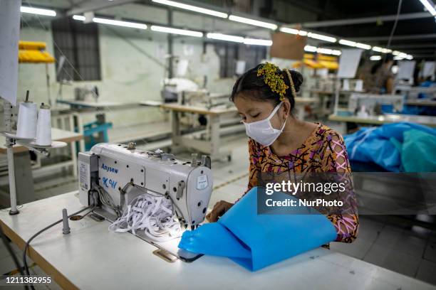 Worker makes disposable surgical gowns for healthcare workers at a garment factory in Yangon, Myanmar on April 30, 2020. The factory produces 1000...