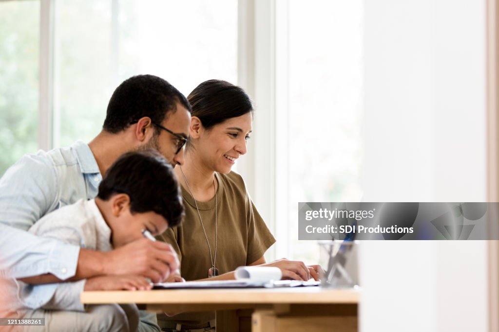 Famille gaie utiliser l’ordinateur portable