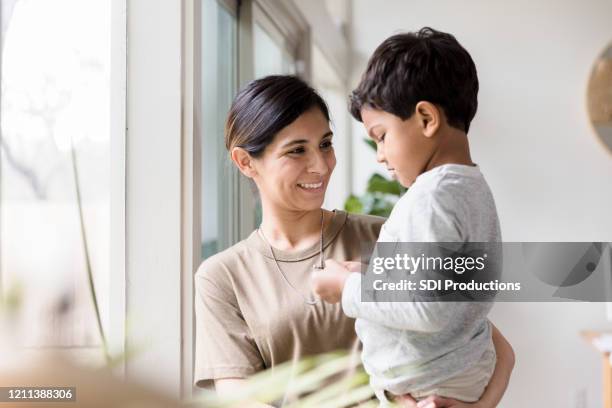 mid adult mom enjoys time with son - armed forces military family stock pictures, royalty-free photos & images