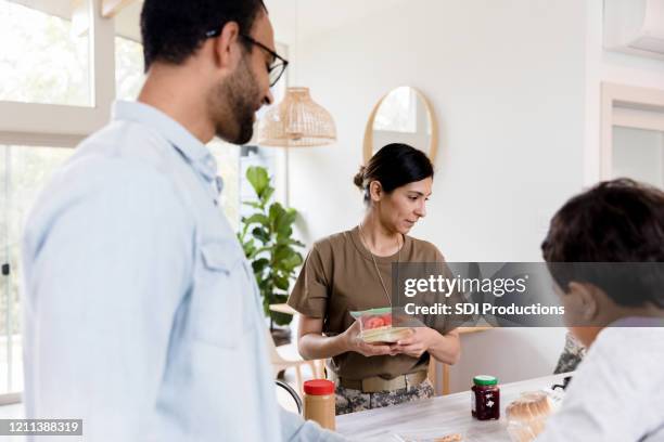 female soldier prepares son's lunch - food bag stock pictures, royalty-free photos & images