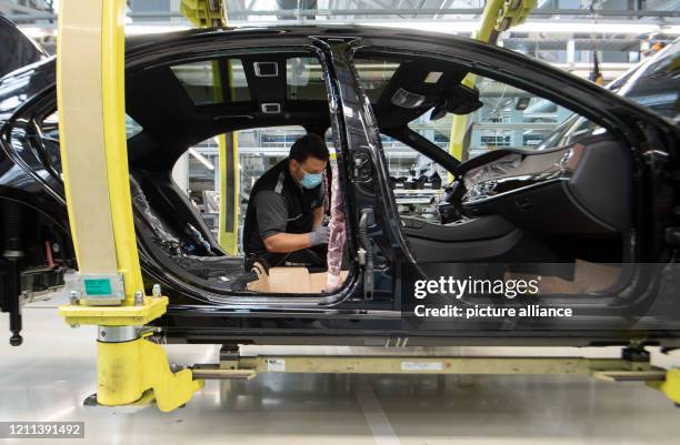 April 2020, Baden-Wuerttemberg, Sindelfingen: An employee of Daimler AG is wearing a mouthguard in the production of the S-Class. Photo: Marijan...