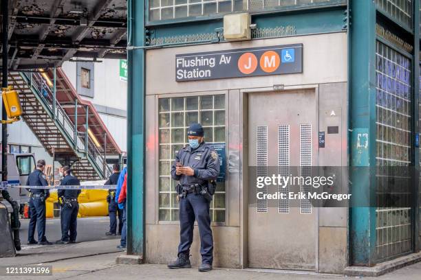 Officer wearing a protective mask. An unauthorized person initially on the tracks climbed on the roof of the Flushing Avenue subway station causing...