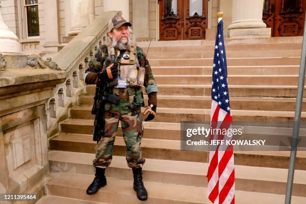 Armed protesters provide security as demonstrators take part in an "American Patriot Rally," organized on April 30 by Michigan United for Liberty on...