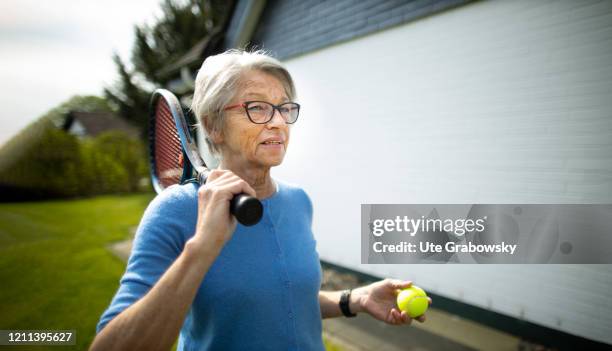In this photo illustration an old woman carries her tennis racket over her shoulder on the way to the tennis court on April 28, 2020 in Radevormwald,...