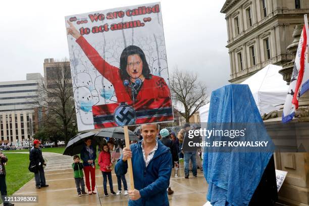 Protestor with a sign that has Michigan Gov. Gretchen Whittmer depicted as Adolph Hitler is seen at an American Patriot Rally organized by Michigan...