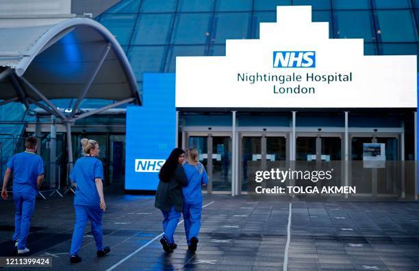 Medical staff from Britain's NHS in scrubs walk outside the ExCeL London exhibition centre, which has been transformed into the "NHS Nightingale"...