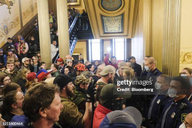 Protesters gather outside the doors of the chamber room at the Michigan Capitol Building in Lansing, Michigan, U.S., on Thursday, April 30, 2020....