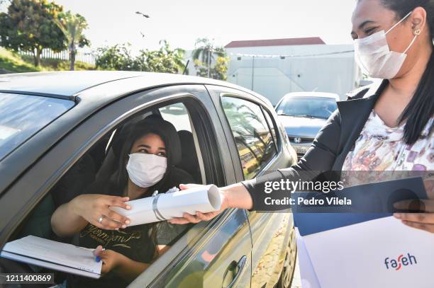 Graduate from the medical and nursing school of Faseh University receives the diploma at a drive-thru ceremony to avoid spread of Coronavirus amid...
