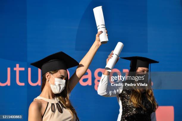 Graduates of the medical and nursing school from Faseh University celebrate wearing facemask after receiving their diplomas at a drive-thru ceremony...