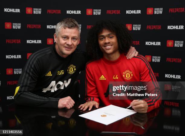 Tahith Chong of Manchester United poses with Manager Ole Gunnar Solskjaer after signing a new contract with Manchester United at Aon Training Complex...