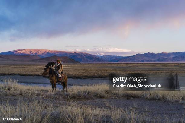 portrait of eagle hunter on horse in steppe in mongolia - mongolian culture stock pictures, royalty-free photos & images