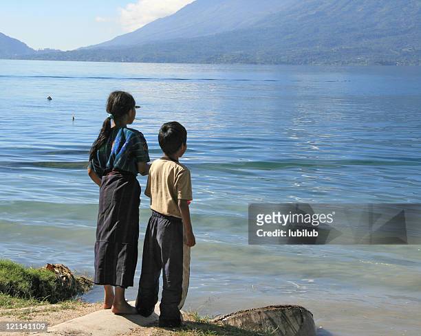 mayan girl and boy by lake atitlan in guatemala - guatemala family stock pictures, royalty-free photos & images