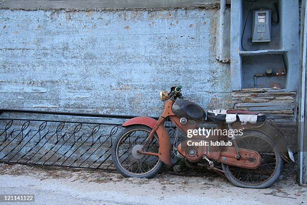 rusty old  motorcycle by blue wall in greece - old motorcycles bildbanksfoton och bilder