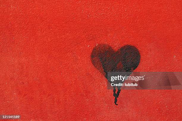 graffiti heart spraypainted on red wall - love concept - red wall stockfoto's en -beelden