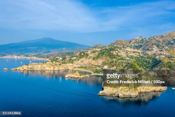 coastline of mediterranean sea and mt etna in background, taormina, sicily, italy - mt etna fotografías e imágenes de stock
