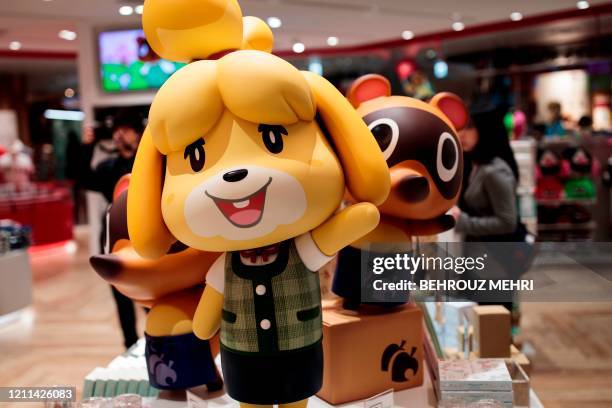 This picture taken on November 19, 2019 shows dolls of Nintendo game characters Isabelle , known as Shizue in Japan, and Tom Nook , known in Japan as...