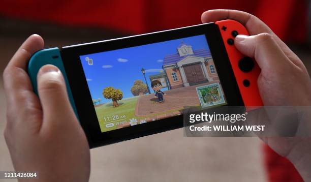 This photo taken on April 29, 2020 shows Australian high school teacher Dante Gabriele playing Nintendo's Animal Crossing at home in Melbourne during...