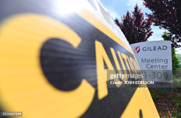 Caution sign sits on a sidewalk in front of the Gilead Sciences headquarters in Foster City, California on April 30, 2020. Gilead Science's...