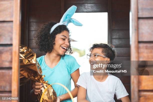 siblings celebrating easter in public park - easter egg hunt outside stock pictures, royalty-free photos & images