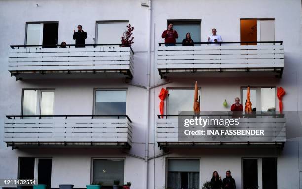 People applaud on their balconies during a concert for the neighbours in a courtyard in Dortmund, western Germany, on April 30 amid the novel...