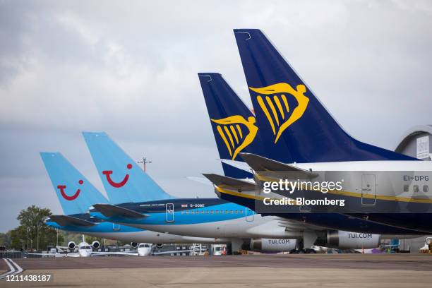Passenger aircraft, operated by Ryanair Holdings Plc, right, stand near passenger aircraft, operated by Tui AG, at London Luton Airport in Luton,...