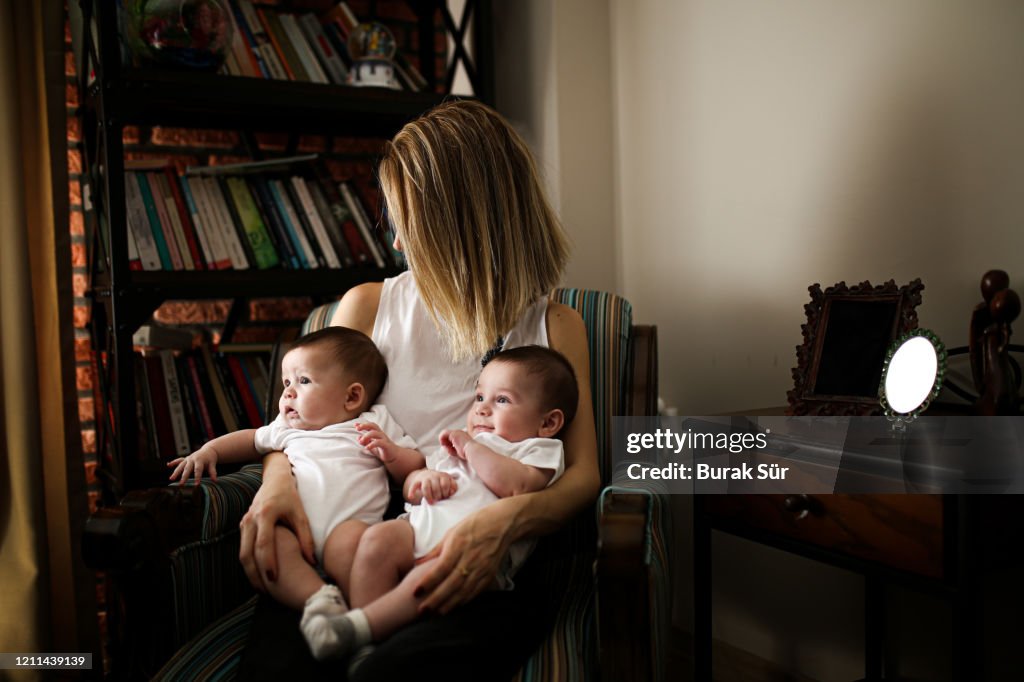 Madre abraza a sus hijos gemelos