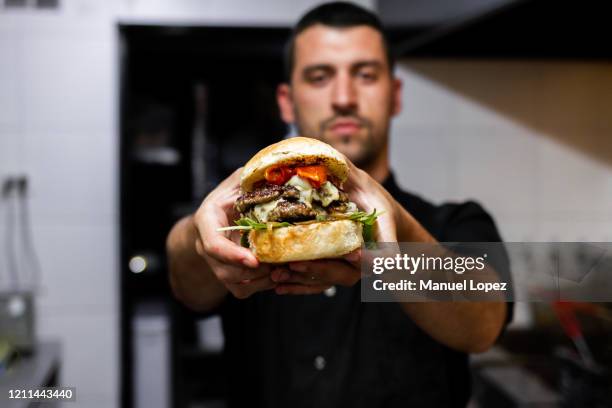 professional latin chef hold a burger - sandwich shop stock pictures, royalty-free photos & images