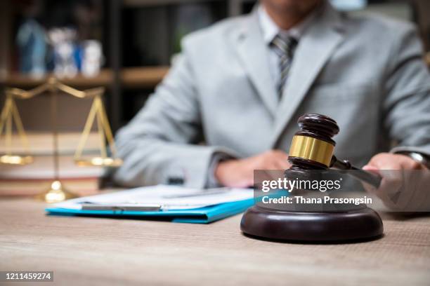 cropped hands of judge by gravel at table - courtroom jurors judge stock pictures, royalty-free photos & images