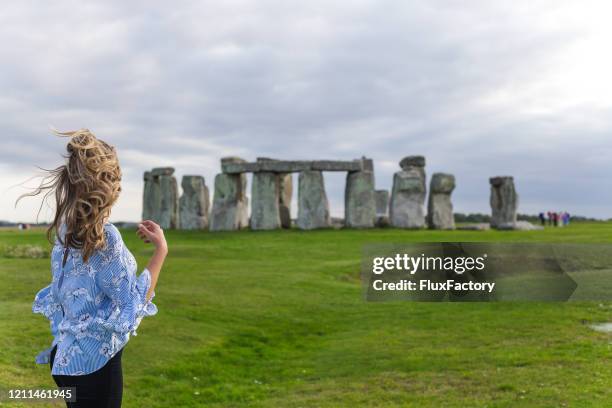 beautiful blonde girl looking at stonehenge - stonehenge stock pictures, royalty-free photos & images