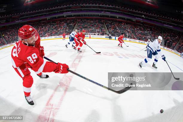 Sam Gagner of the Detroit Red Wings shoots the puck along the boards past Luke Schenn of the Tampa Bay Lightning during an NHL game at Little Caesars...