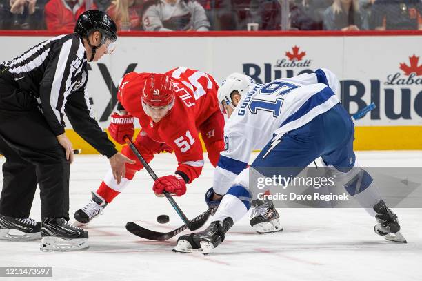 Linesman Scott Cherrey drops the puck between Valtteri Filppula of the Detroit Red Wings and Barclay Goodrow of the Tampa Bay Lightning during an NHL...