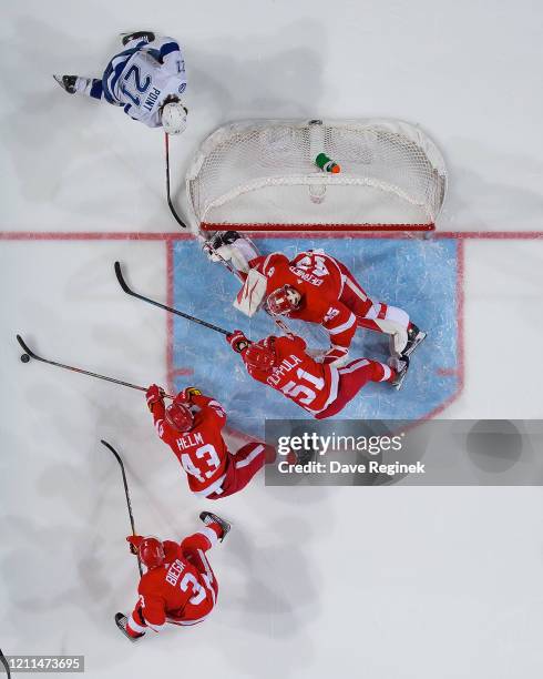 Darren Helm of the Detroit Red Wings skates after a loose puck next to teammates Valtteri Filppula, Alex Biega and goaltender Jonathan Bernier as...