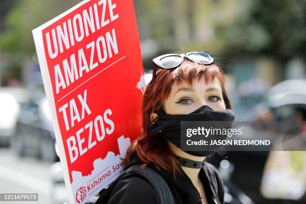 Protesters wearing face masks participate in a protest at the Amazon Spheres to demand the Seattle City Council tax the city's largest businesses in...