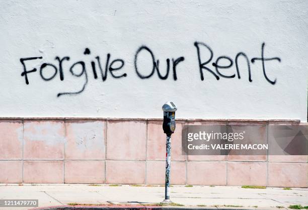 Graffiti asking for rent forgiveness is seen on a wall on La Brea Ave on National May Day amid the Covid-19 pandemic, May 1 in Los Angeles,...