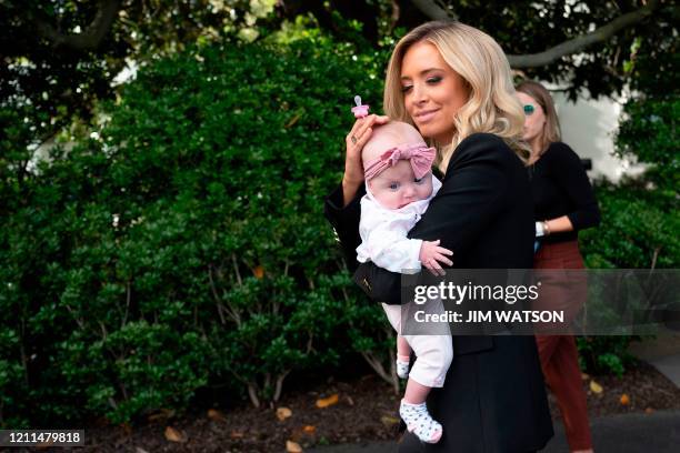 White House Press Secretary Kayleigh McEnany walks with her daughter after watching US President Donald Trump depart the White House in Washington,...