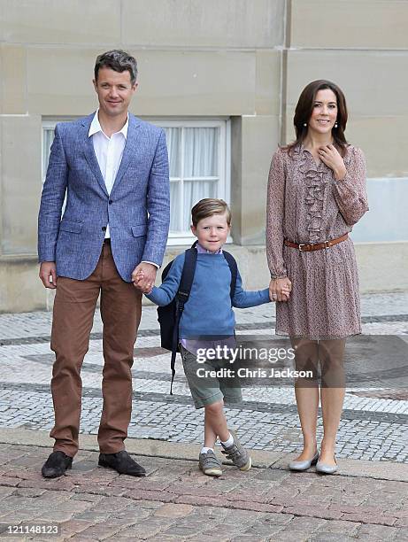 Crown Prince Frederik of Denmark and Crown Princess Mary of Denmark pose for photographs with their son Prince Christian of Denmark on his first day...