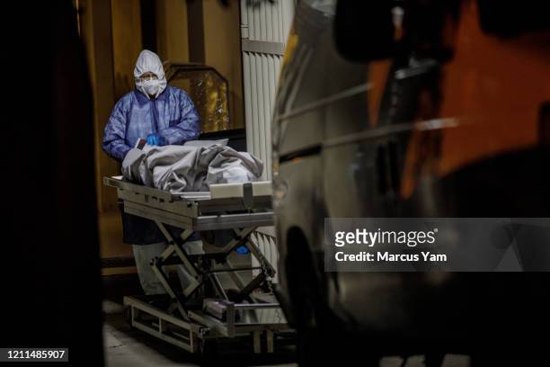 Medical worker checks paperwork before handing off a corpse for transfer to a van that will bring it to the morgue, at Tijuana General Hospital, in...