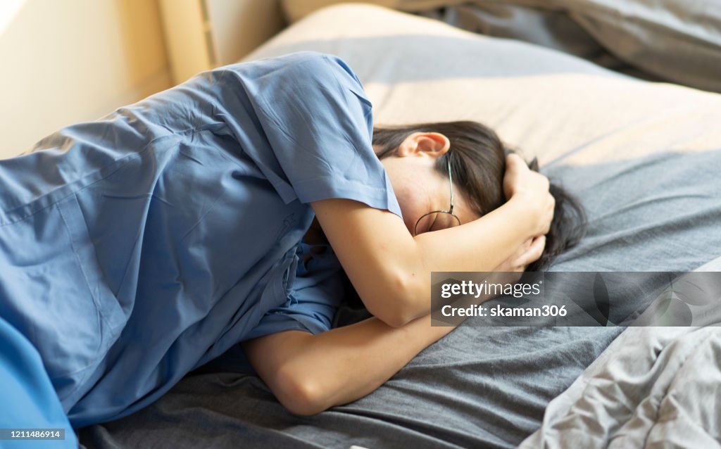 Asian female feeling hurt and painful menstruation period on the bed and holding tablet medicine
