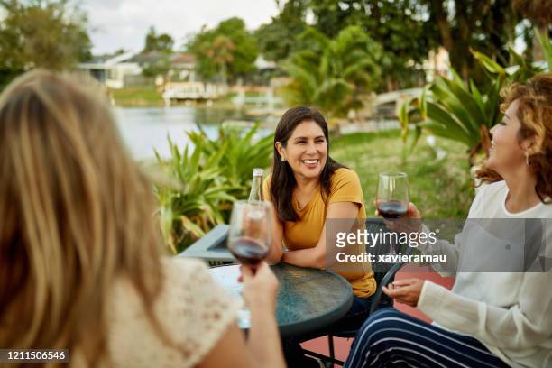 female friends enjoying wine and beer outdoors in afternoon - celebration fl stock pictures, royalty-free photos & images