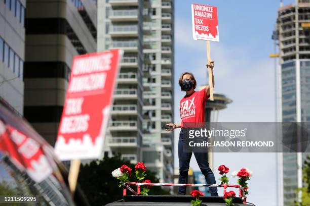Protesters stand on their cars and block traffic as they participate in a "car caravan" protest at the Amazon Spheres to demand the Seattle City...