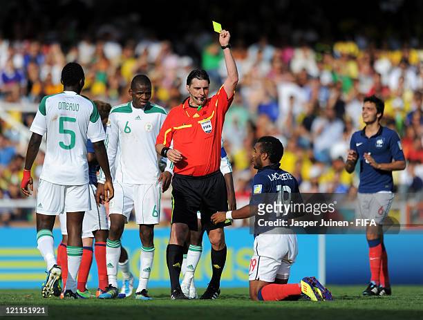 Referee Dario Ubriaco shows Alexandre Lacazette of France a yellow card during the FIFA U-20 World Cup Colombia 2011 quarter final match between...