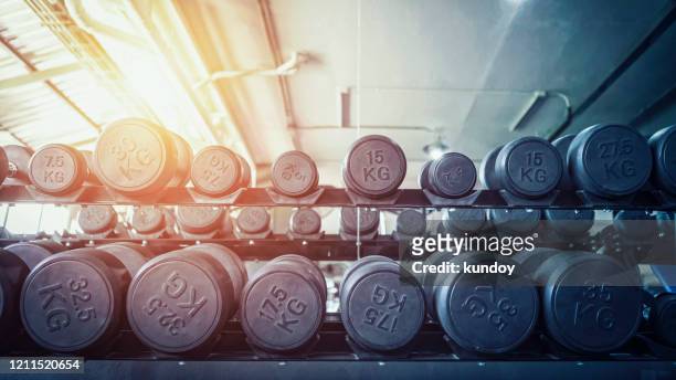 row of dumbbells in sport club. exercise in gym for healthy concept. - mass unit of measurement stock pictures, royalty-free photos & images