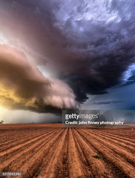 supercell thunderstorm over a drought cracked earth, texas. - côte du golfe photos et images de collection