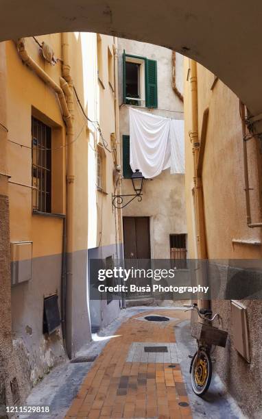 traditional narrow alley in the historic center of menton, a coastal town in the alpes-maritimes department in the provence-alpes-côte d'azur along the french riviera, france - region provence alpes côte dazur stock-fotos und bilder