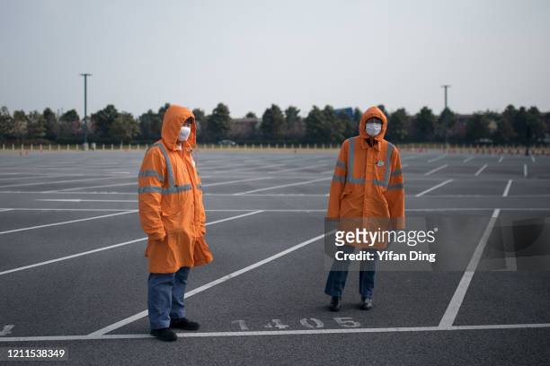 Staff workers wearing protective masks in public parking lot of Shanghai Disneyland Park on March 10, 2020 in Shanghai, China. The Shanghai Disney...
