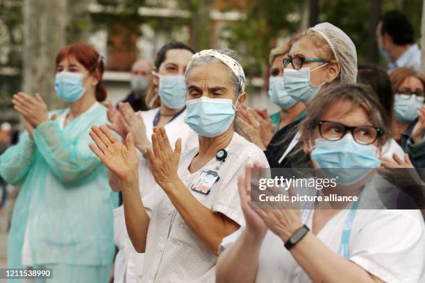 April 2020, Spain, Madrid: Sanitary workers of the Hospital San Carlos, get out of the building as every day at 8 PM to honour the people and the...