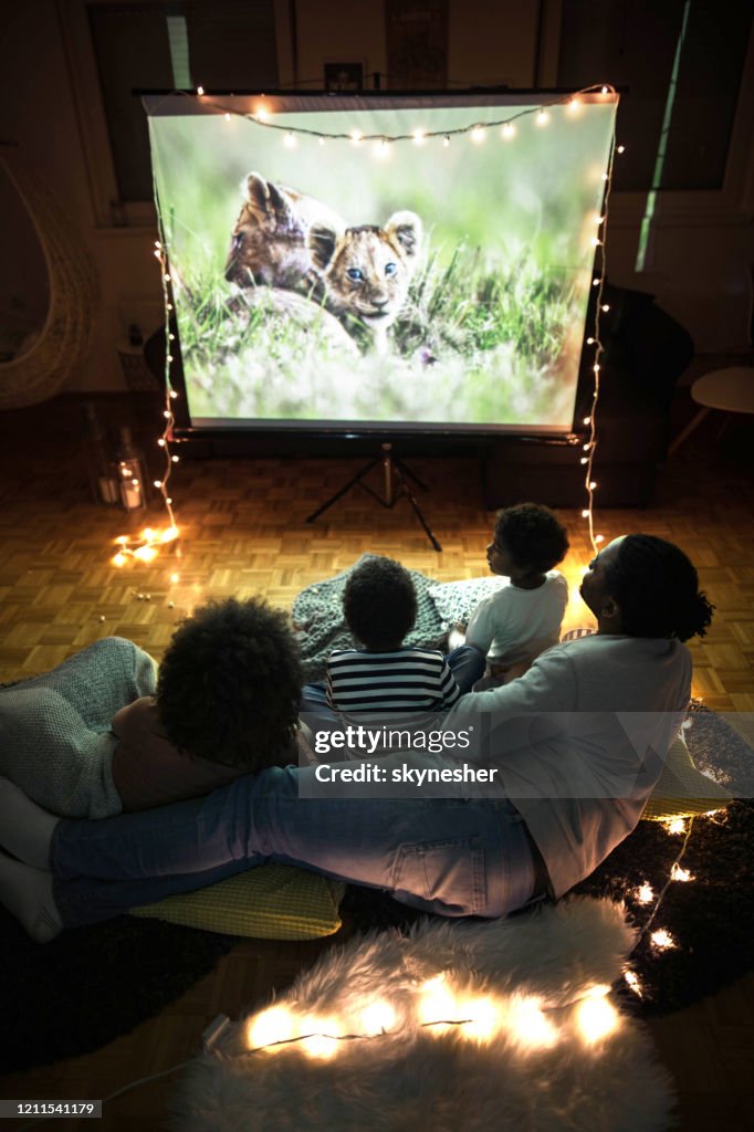 Above view of a relaxed black family having a movie night at home.