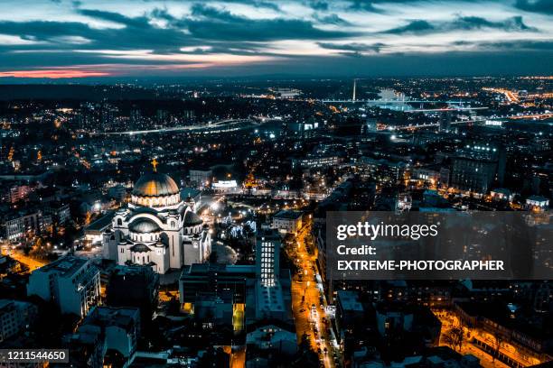 belgrade city lights and the illuminated st. sava temple, taken from a drone at golden hour - belgrade skyline imagens e fotografias de stock