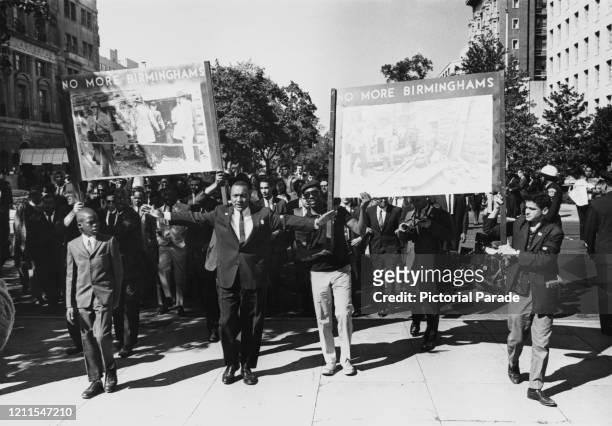 People at a civil rights demonstration holding posters reading 'No More Birminghams', in reference to the bombing of the 16th Street Baptist Church ,...